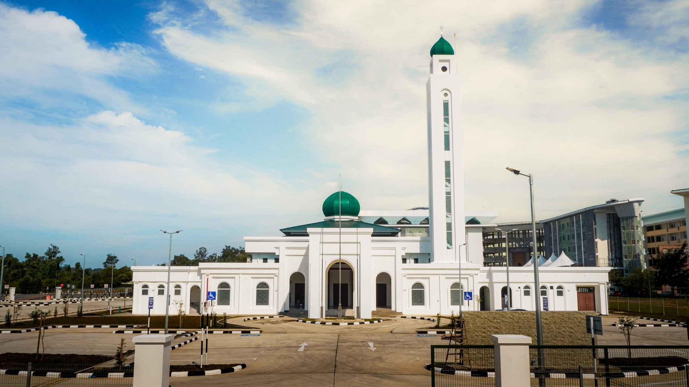 The front of Masjid Baru RPN Kg Rimba, with its central arched entrance, green dome and minaret